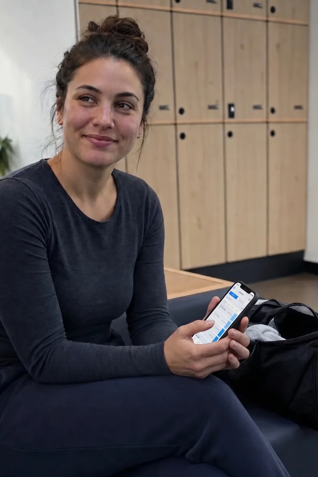 Member using the gym's branded app while relaxing in the lounge