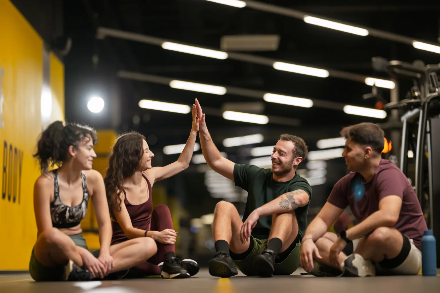Members sharing a high five on the gym floor after a session